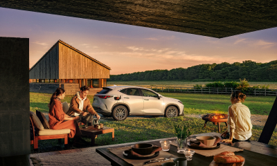Charging NX PHEV in a field. People sit mulling around enjoying food and drink.