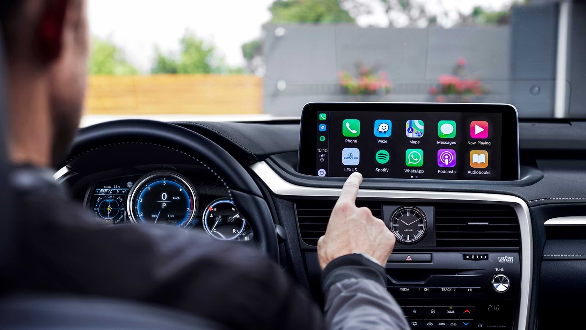 Outstretched hand selects Apple CarPlay on a Lexus infotainment screen.